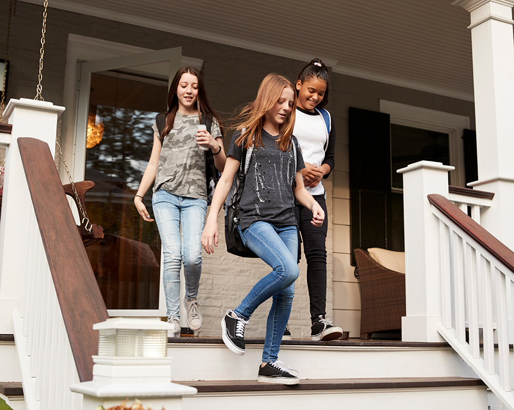 back-to-school image: three girls walking down porch steps