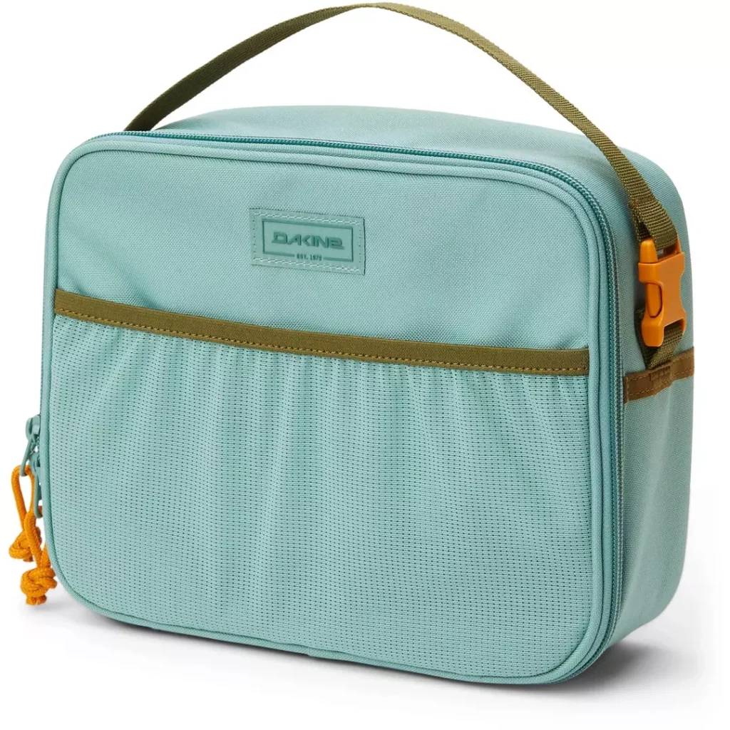 pale teal rectangular Dakine lunch bag with a contrast green/brown carry handle at top with an orange click-buckle closure, a mesh drop-in front pocket and a tonal pale teal Dakine logo patch