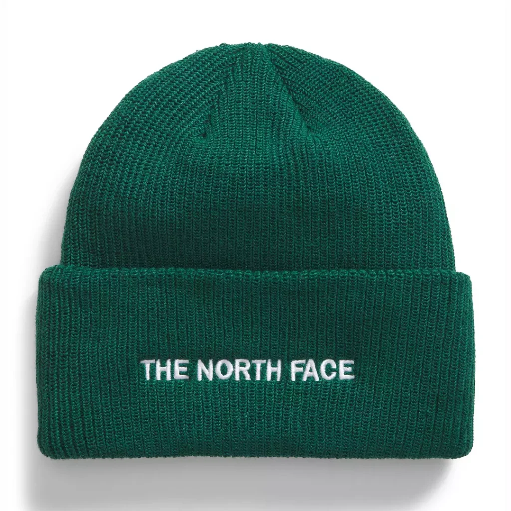 Deep forest green The North Face beanie with a low profile, simple ribbed knit structure, a wide cuffed design and small contrast white "The North Face" lettering at the cuff