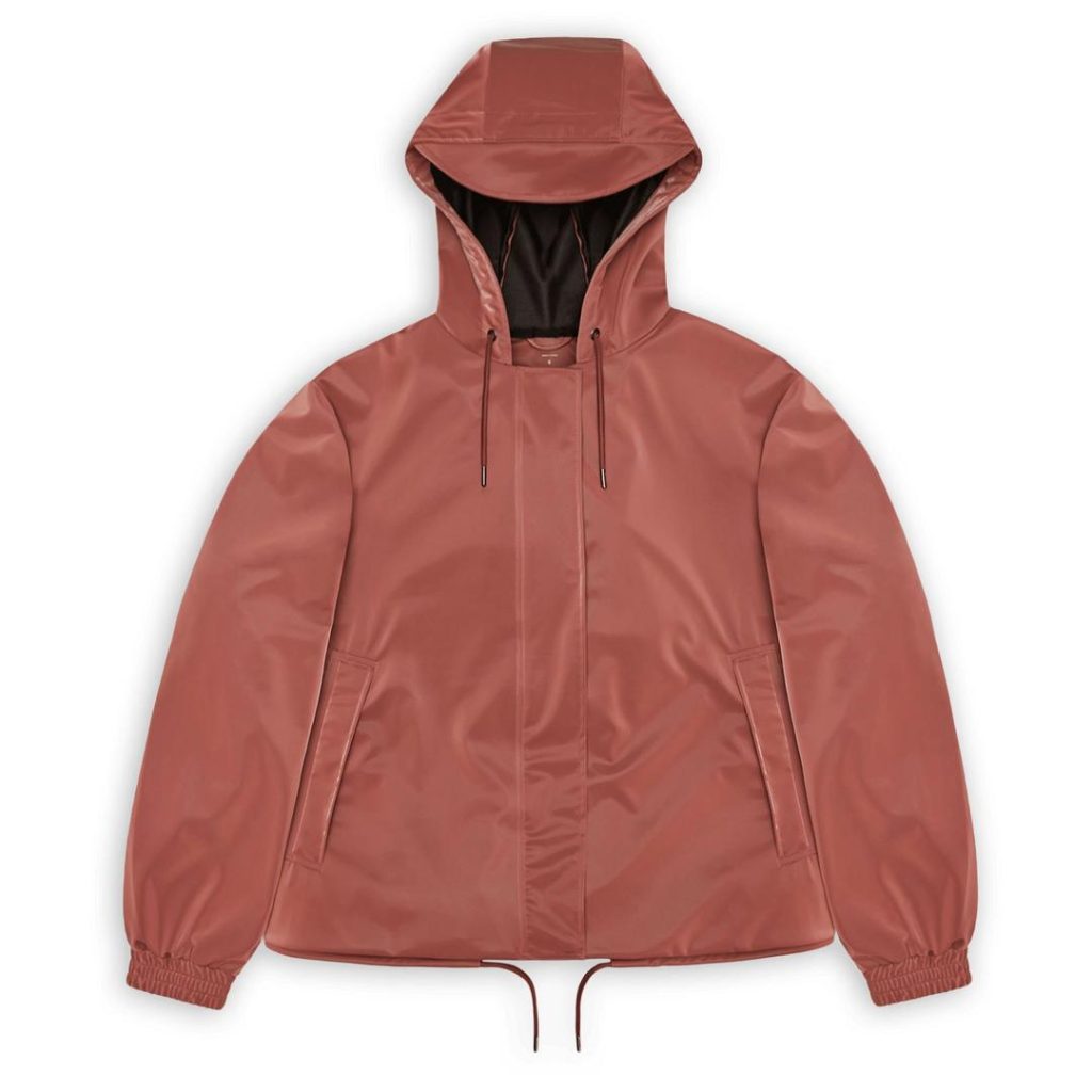 rust coloured RAINS rain jacket with a drawstring at the hem, hidden front zip closure, stretchy elastic cuffs, side welt pockets, a drawstring hood with a protective brim; back to school style checklist